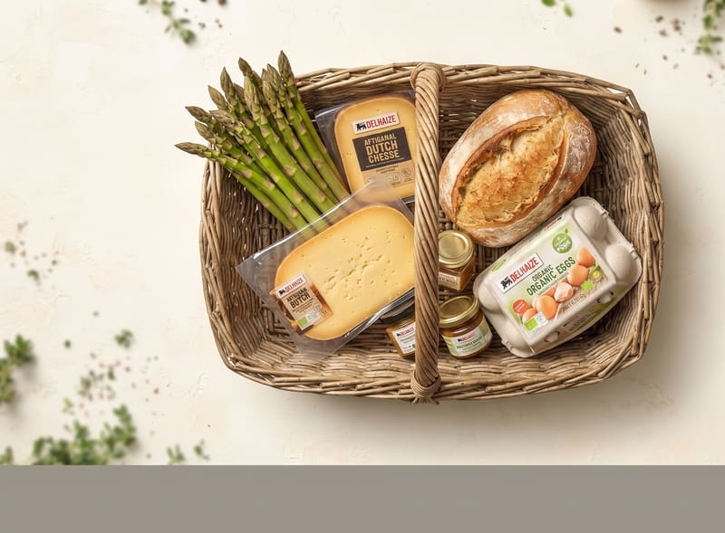 Rieten mand met kaas, brood, eieren en asperges